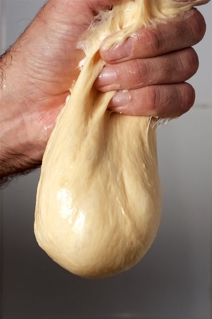 Mano che solleva un impasto lievitato